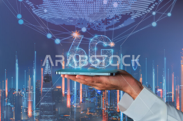 صورة مقربة ليد رجل عربي سعودي خليجي أمام أبراج وناطحات سحاب المملكة ، يحمل بيده جهاز هاتف محمول ذكي  عليه اختصار الجيل السادس للشبكات 6G بتقنية الهولوجرام ،  يعلوها شبكة عنكبوتية متصلة بالكرة الأرضية ، استخدام خاصية الهولوجرام ثلاثية الأبعاد .