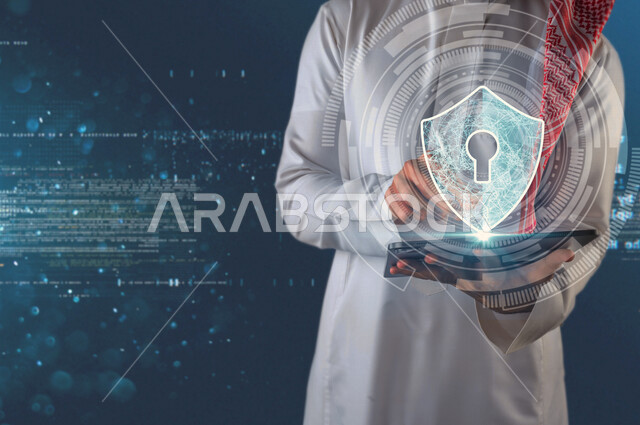 صورة مقربة لرجل عربي سعودي خليجي يحمل بيديه جهاز تقني ذكي عليه أيقون لقفل الأمان محاطة بعدسة تصوير  بتقنية الهولوجرام ، استخدام خاصية الهولوجرام ثلاثية الأبعاد .