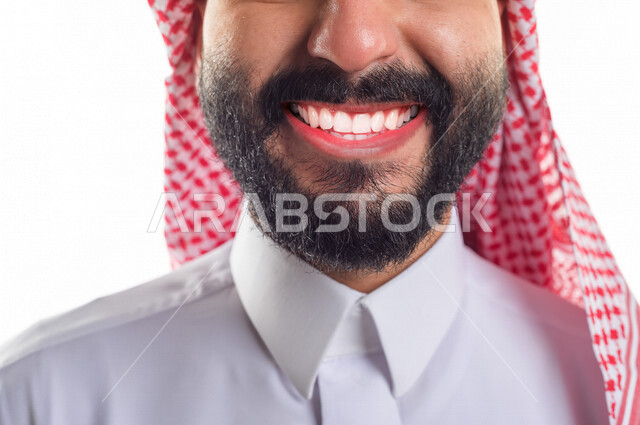 صورة مقربة لابتسامة بوجه رجل عربي خليجي سعودي ، تجميل الأسنان و الابتسامة المعالجة ، ايماءات و تعابير جسدية تدل على السعادة والفرح .