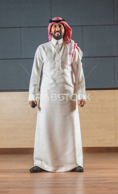 مقدم مسرحي سعودي خليجي على خشبة المسرح يتفاعل مع الجمهور ،  تقديم العروضات المسرحية ، القاء الخطابات ، الحوارات و النقاشات ، اداء تمثيلي ، ايماءات وجه و يدين مختلفة ، الفن المسرحي 