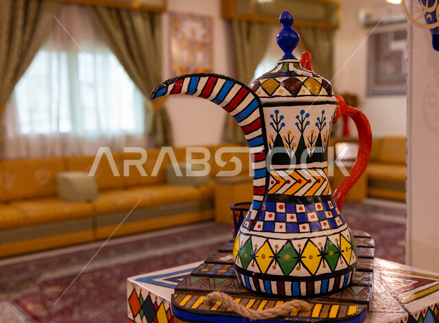 منتجات محلية وطنية, قطع أثرية في المتحف التراثي في منطقة عسير, صورة مقربة لأبريق قهوة  بنقوش شعبية وزخارف يدوية ملونة, أماكن جذب واستقطاب الزوار من شتى أنحاء العالم, التمسك بالتراث الخليجي القديم, مناطق ومعالم تاريخية في المملكة العربية السعودية