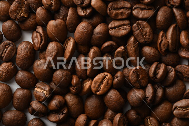 حبوب البن (بذرة نبات القهوة) نوع من أنواع المشروبات المنشطة ذهنياً , بذور البن المحمصة ,  بذور البن الطازجة الطبيعية  , خلفية بيضاء