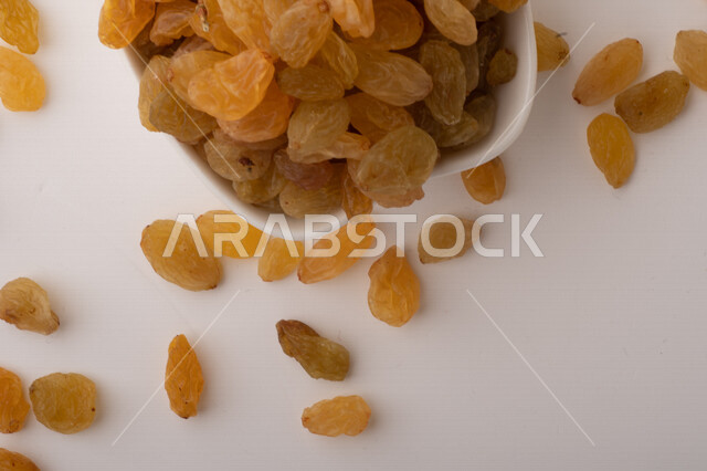 الزبيب (العنب المجفف) نوع من أنواع الفواكهة المجففة ,  الزبيب المجفف , فواكة مجففة صحية ولذيذة , عنصر غذائي مفيد للصحة, خلفية بيضاء 