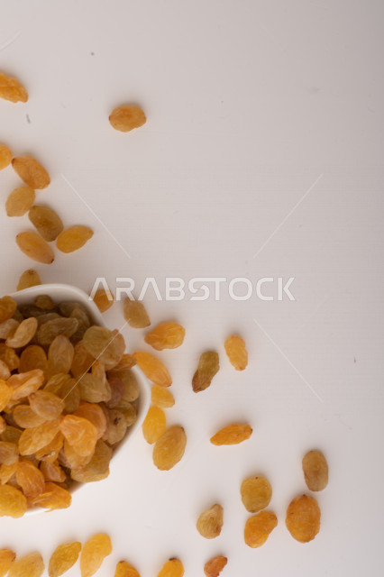 الزبيب (العنب المجفف) نوع من أنواع الفواكهة المجففة ,  الزبيب المجفف , فواكة مجففة صحية ولذيذة , عنصر غذائي مفيد للصحة, خلفية بيضاء 