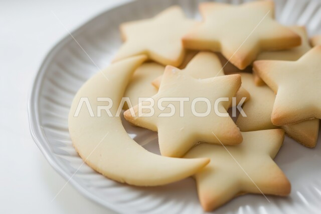 الاحتفال بالمناسبات والأعياد الدينية، صورة مقربة لطبق من البسكويت على شكل هلال ونجمة، الحلويات والسناكات الشهية، منتج وطني محلي، الأطعمة والمأكولات السريعة