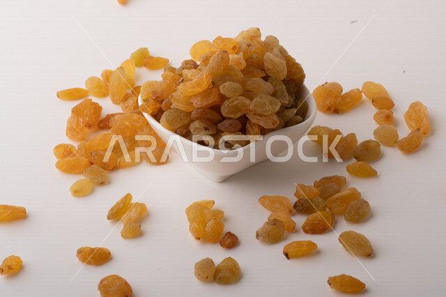 الزبيب (العنب المجفف) نوع من أنواع الفواكهة المجففة ,  الزبيب المجفف , فواكة مجففة صحية ولذيذة , عنصر غذائي مفيد للصحة, خلفية بيضاء 