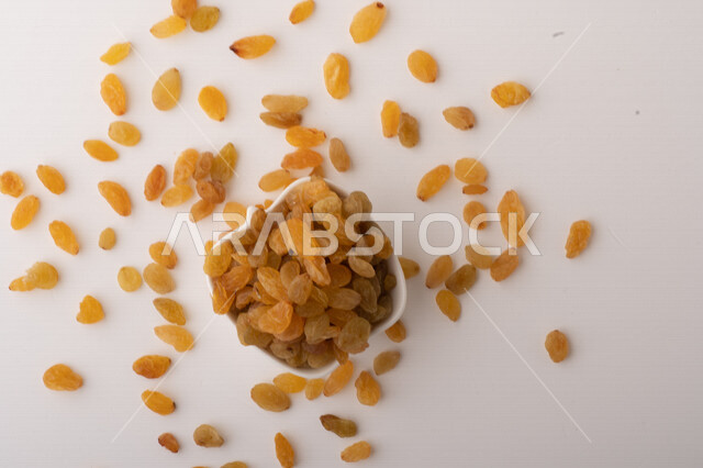 الزبيب (العنب المجفف) نوع من أنواع الفواكهة المجففة ,  الزبيب المجفف , فواكة مجففة صحية ولذيذة , عنصر غذائي مفيد للصحة, خلفية بيضاء 