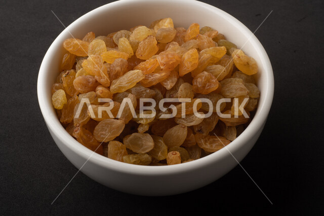 الزبيب (العنب المجفف) نوع من أنواع الفواكهة المجففة , صورة مقربة للزبيب المجفف , فواكة مجففة صحية ولذيذة , عنصر غذائي مفيد للصحة , خلفية سوداء