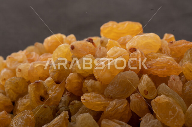 الزبيب (العنب المجفف) نوع من أنواع الفواكهة المجففة , صورة مقربة للزبيب المجفف , فواكة مجففة صحية ولذيذة , عنصر غذائي مفيد للصحة , خلفية سوداء