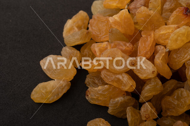 الزبيب (العنب المجفف) نوع من أنواع الفواكهة المجففة , صورة مقربة للزبيب المجفف , فواكة مجففة صحية ولذيذة , عنصر غذائي مفيد للصحة , خلفية سوداء