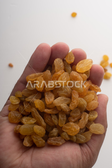 الزبيب (العنب المجفف) نوع من أنواع الفواكهة المجففة ,  الزبيب المجفف , فواكة مجففة صحية ولذيذة , عنصر غذائي مفيد للصحة, خلفية بيضاء 