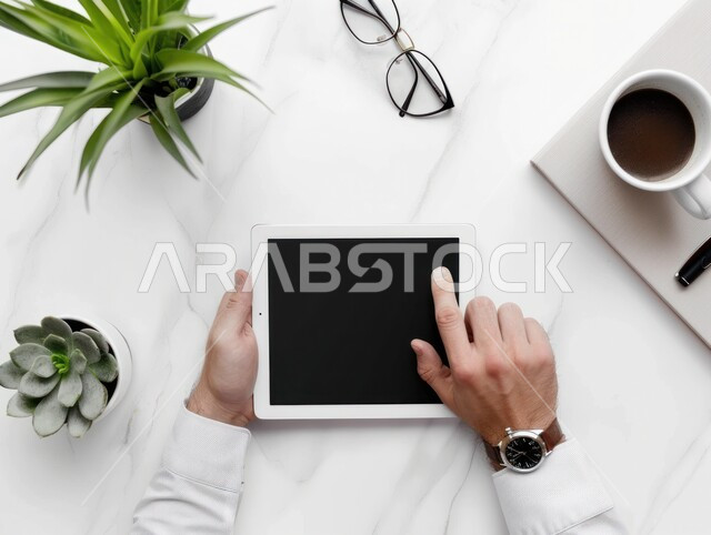 Electronic development and technological growth, top view of the hands of an Arab Gulf man holding a tablet device while completing work and tasks in the office, Saudi office jobs and professions, use of modern and advanced technologies, white background