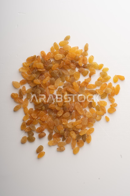 الزبيب (العنب المجفف) نوع من أنواع الفواكهة المجففة ,  الزبيب المجفف , فواكة مجففة صحية ولذيذة , عنصر غذائي مفيد للصحة, خلفية بيضاء 