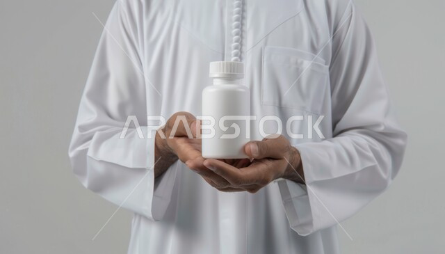 تناول الدواء بوصفة طبية مناسبة، أخذ جرعات الأدوية بشكل صحيح, أدوية لمعالجة الحالات المرضية، استخدام العلاج الطبي اللازم، الوقاية من الأمراض والعدوى، رجل عربي سعودي خليجي يرتدي الزي التقليدي يحمل بيده علبة الحبوب