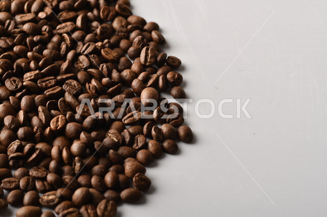 حبوب البن (بذرة نبات القهوة) نوع من أنواع المشروبات المنشطة ذهنياً , بذور البن المحمصة ,  بذور البن الطازجة الطبيعية  , خلفية بيضاء