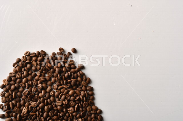 حبوب البن (بذرة نبات القهوة) نوع من أنواع المشروبات المنشطة ذهنياً , بذور البن المحمصة ,  بذور البن الطازجة الطبيعية  , خلفية بيضاء