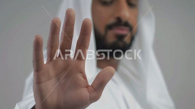  اشارات يدين تدل على الأمر بالنهي عن فعل شيء ما, الصمت و التوقف عن الكلام، رجل عربي خليجي سعودي يرتدي الثوب والغتره يقوم برفع كفه للأعلى بإيماءات عدم الإعجاب