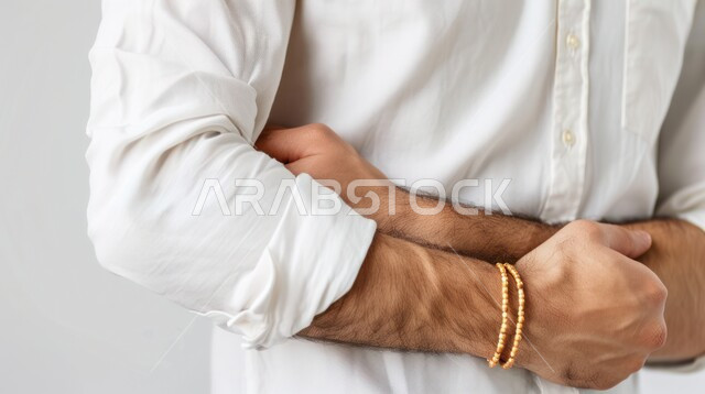 مفهوم أمراض والتهابات الجهاز الهضمي, صورة مقربة لرجل عربي خليجي سعودي، يرتدي الثوب، يعاني من آلام البطن والمعدة ، بإيماءات يدين مختلفة تدل على الوجع والألم ، خلفية بيضاء