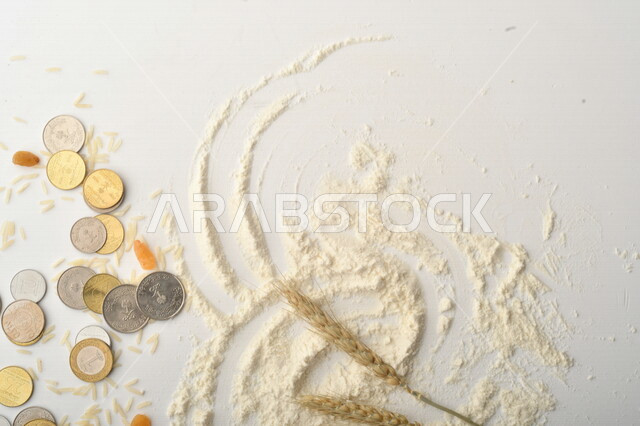 مجموعة من الأرز والزبيب والقمح والطحين والعملات المعدنية على خلفية بيضاء .