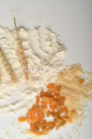 مجموعة من الأرز والزبيب والطحين على خلفية بيضاء .