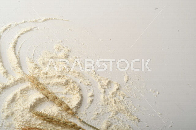 A bunch of rice, raisins and flour on a white background.