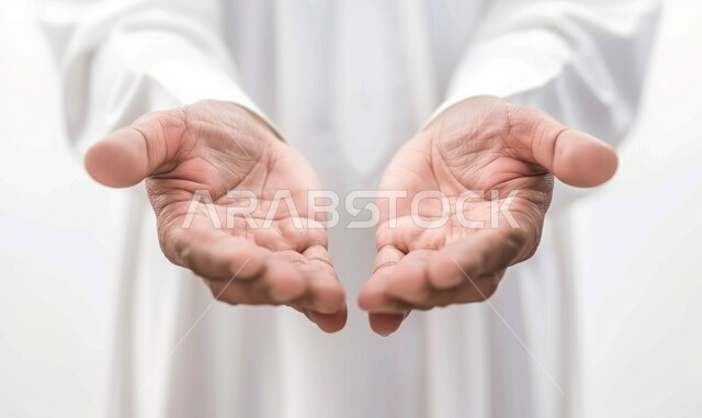 محاولة حمل شيء ما, تقديم عنصر هولوجرامي, بورتريه مقرب لأيدي رجل عربي خليجي سعودي يرتدي الثوب التقليدي يقوم بفتح كفيه, مفهوم العرض والتقديم, خلفية بيضاء