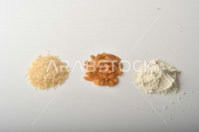 مجموعة من الأرز والزبيب والطحين على خلفية بيضاء .