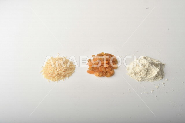 مجموعة من الأرز والزبيب والطحين على خلفية بيضاء .