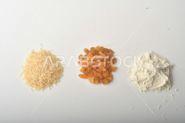 مجموعة من الأرز والزبيب والطحين على خلفية بيضاء .
