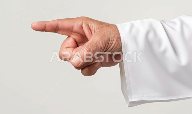 Pointing towards something and specifying a target, close-up portrait of a Saudi Arabian Gulf man's hand wearing a traditional thobe pointing with his index finger to a specific place, white background