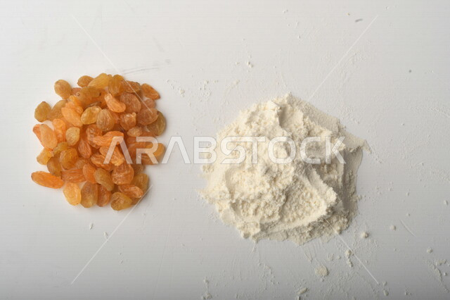 مجموعة من الأرز والزبيب والطحين على خلفية بيضاء .