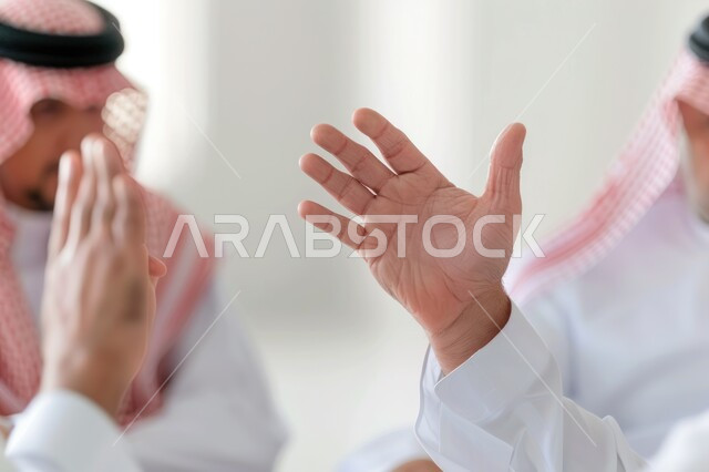 فتح كف اليد بإيماءات الوداع, التفاعل والاندماج أثناء الحوار والنقاش, مفهوم السلام والتحية عن بعد, صورة مقربة لأيدي رجلين عربيين خليجيين سعوديين يرتديان الثوب التقليدي يرفعان يديهما للأعلى