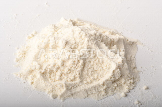 A handful of flour lay on a white table.