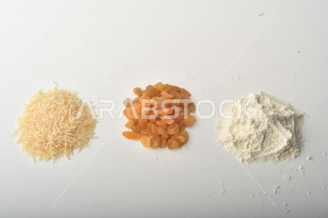 مجموعة من الأرز والزبيب والطحين على خلفية بيضاء .