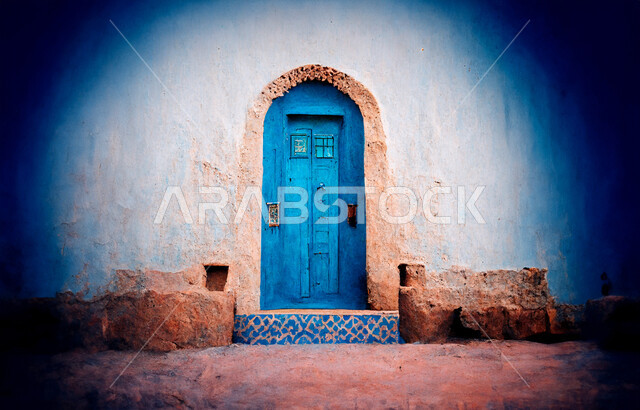 المدن والقرى التاريخية، التصميم المعماري العربي القديم للأبواب الخشبية الأثرية القديمة، النقوش الفنية على الطراز الإسلامي، البيوت القديمة المبنية من الطين، باب خشبي مزخرف باللون الأزرق لمنزل طيني، أماكن تراثية في المملكة العربية السعودية