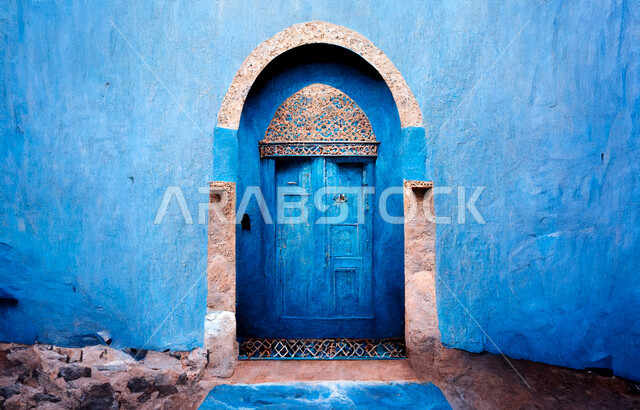 النقوش الفنية على الطراز الإسلامي، المدن والقرى التاريخية، التصميم المعماري العربي القديم للأبواب الخشبية الأثرية القديمة، باب خشبي مزخرف باللون الأزرق لمنزل طيني، أماكن تراثية في المملكة العربية السعودية، البيوت القديمة المبنية من الطين