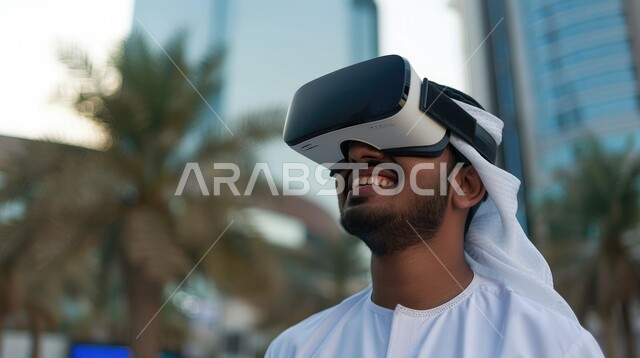 Integration and interaction with virtual reality, feeling fun and entertainment by simulating the imaginary world, technological devices and modern technologies, close-up image of a Saudi Arabian Gulf man wearing 3D VR glasses, gestures of pleasure and joy