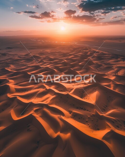 Sunset view on the sand deserts of the Arabian Gulf, sand dunes in desert landscapes, vast areas and lands in the Kingdom of Saudi Arabia, plateaus and hills of soft golden sand in the Arabian Desert