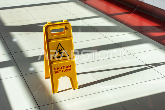 لافتة خطر الأرضية المبللة باللغة الإنجليزية داخل مترو دبي، اللافتات التحذيرية باللون الأصفر، لوحات إرشادية داخل المباني، لوحة تحذير من الوقوع في المحطة في الامارات العربية المتحدة