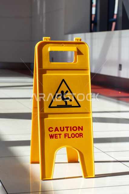 لافتة خطر الأرضية المبللة باللغة الإنجليزية داخل مترو دبي، اللافتات التحذيرية باللون الأصفر، لوحات إرشادية داخل المباني، لوحة تحذير من الوقوع في المحطة في الامارات العربية المتحدة