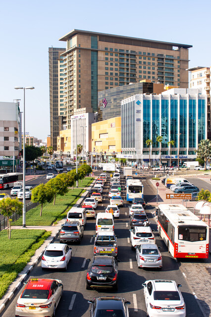 Vehicles during the day on the roads of the United Arab Emirates, means of transportation, traffic congestion of cars in the streets and roads of Dubai, architectural art of buildings and commercial towers