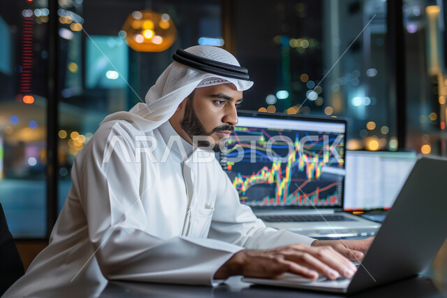 ادارة مهام العمل اليومية في مقر الشركة، مهن ووظائف سعودية، استخدام الاجهزة التقنية الحديثة، صورة مقربة لرجل عربي خليجي سعودي يرتدي الزي التقليدي يجلس في مكتبه يعمل على جهاز الحاسوب المحمول