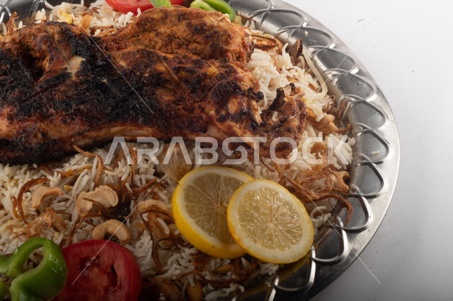 طبق أرز شعبي مع الدجاج المظبي مجهز في المطبخ السعودي ، أرز بني مع الدجاج المزين بالشعرية ، طبق سعودي تقليدي ، مطبخ سعودي تقليدي جاهز ، خلفية بيضاء