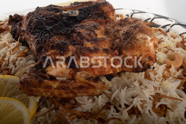Popular rice dish with Madhbi chicken prepared in Saudi kitchen, brown rice with chicken decorated with noodles, traditional Saudi dish, ready-made traditional Saudi kitchen, white background