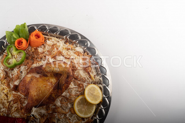 Popular rice dish with Madhbi chicken prepared in Saudi kitchen, brown rice with chicken decorated with noodles, traditional Saudi dish, ready-made traditional Saudi kitchen, white background