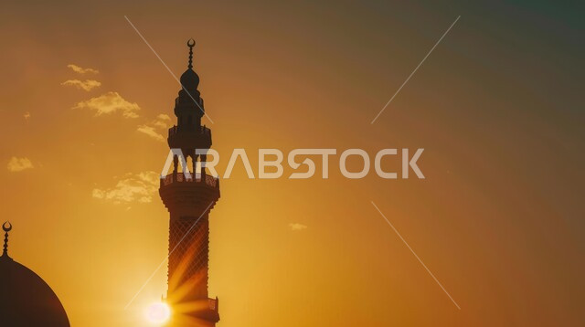 أداء الصلوات والفرائض الدينية ،صورة مئذنة احد المساجد من الاسفل وقت غروب الشمس في المملكة العربية السعودية ، محاوطة الاشعة الشمسية للمئذنة وملامستها للغيوم