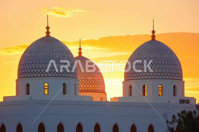 انعكاس أشعة الشمس الصفراء على القبة،صورة ظلية لقبب مسجد في المملكة العربية السعودية وقت غروب الشمس، مفهوم الصلاة والعبادة والتقرب إلى الله تعالى
