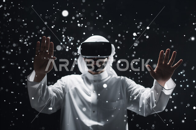 Interacting and merging with virtual reality, trying to touch imaginary elements, feeling fun and entertainment by simulating the imaginary world, technological devices and modern technologies, close-up portrait of a Saudi Arabian Gulf man wearing 3D VR glasses, black background