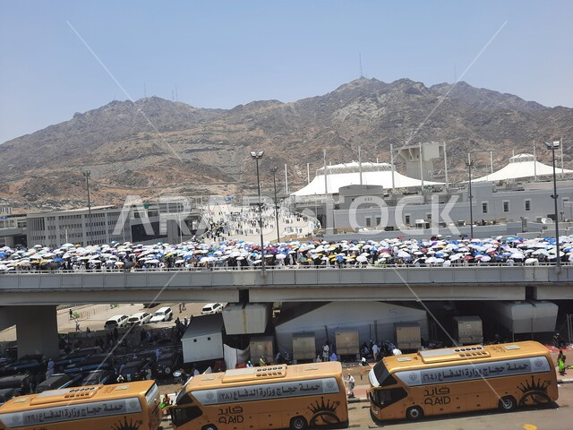 باصات نقل الحجاج والمعتمرين إلى مكة المكرمة, أداء مناسك الحج والعمرة, أماكن ومعالم دينية إسلامية مقدسة في المملكة العربية السعودية, مجموعة من زوار بيت الله الحرام يسيرون على جسر الجمرات