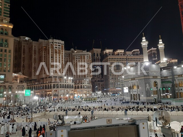 A group of pilgrims in the Grand Mosque in Mecca at night, performing Hajj and Umrah rituals, places and landmarks of the holy Islamic religion in the Kingdom of Saudi Arabia, worship and drawing closer to God